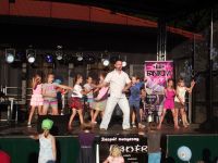 Wspólny taniec grupy dzieci z instruktorem na scenie