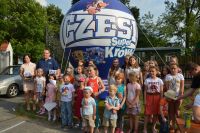 Grupa dzieci pozująca do zdjęcia na tle dmuchanego balonu "Czesio - super krówka"